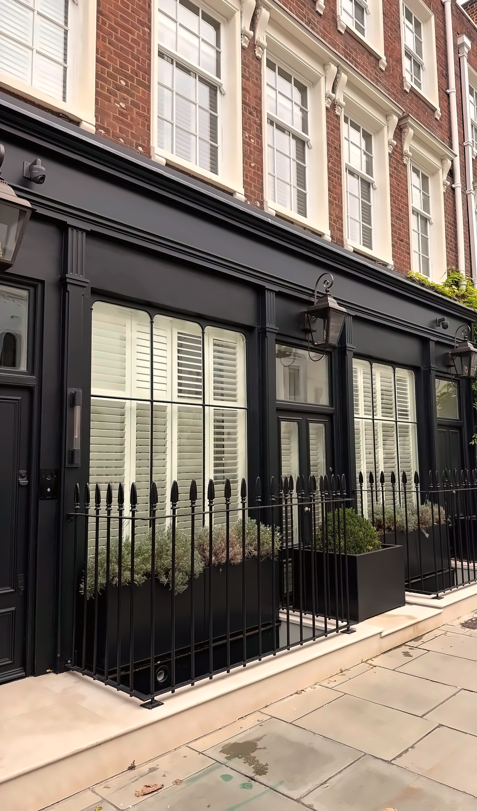 Grade II listed black timber shop front in Maida Vale, London, with bespoke shutters and sash windows by Barnsbury Joinery